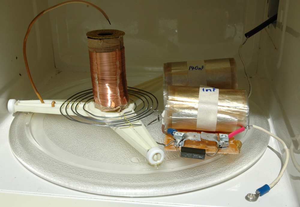 Completed Tesla coil in microwave oven interior.