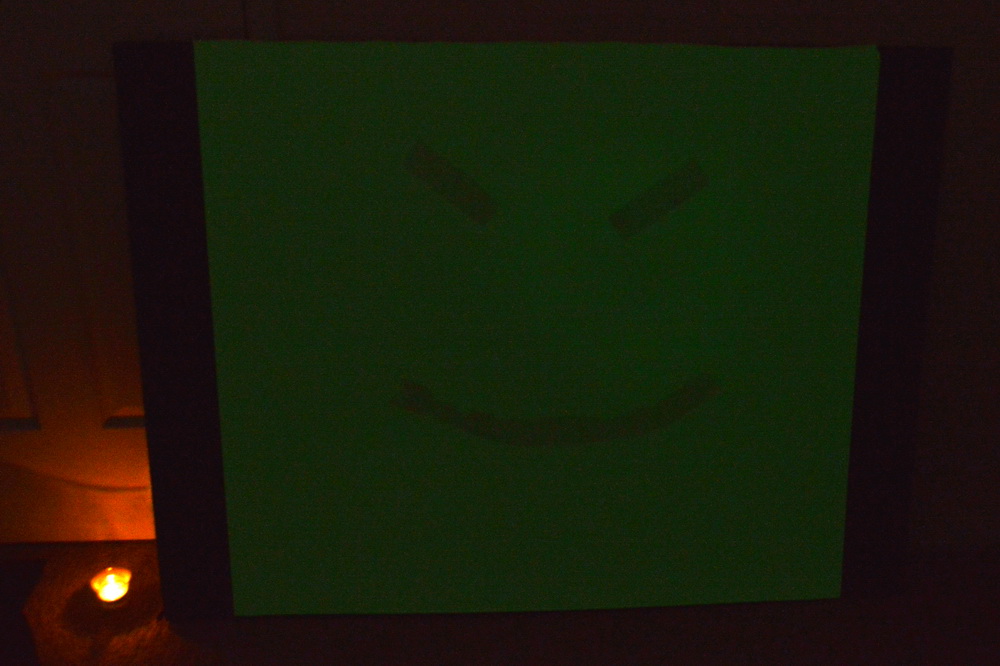 Phosphorescent sheet with smiley face 1 hour after exposure to the sun still shows some effect